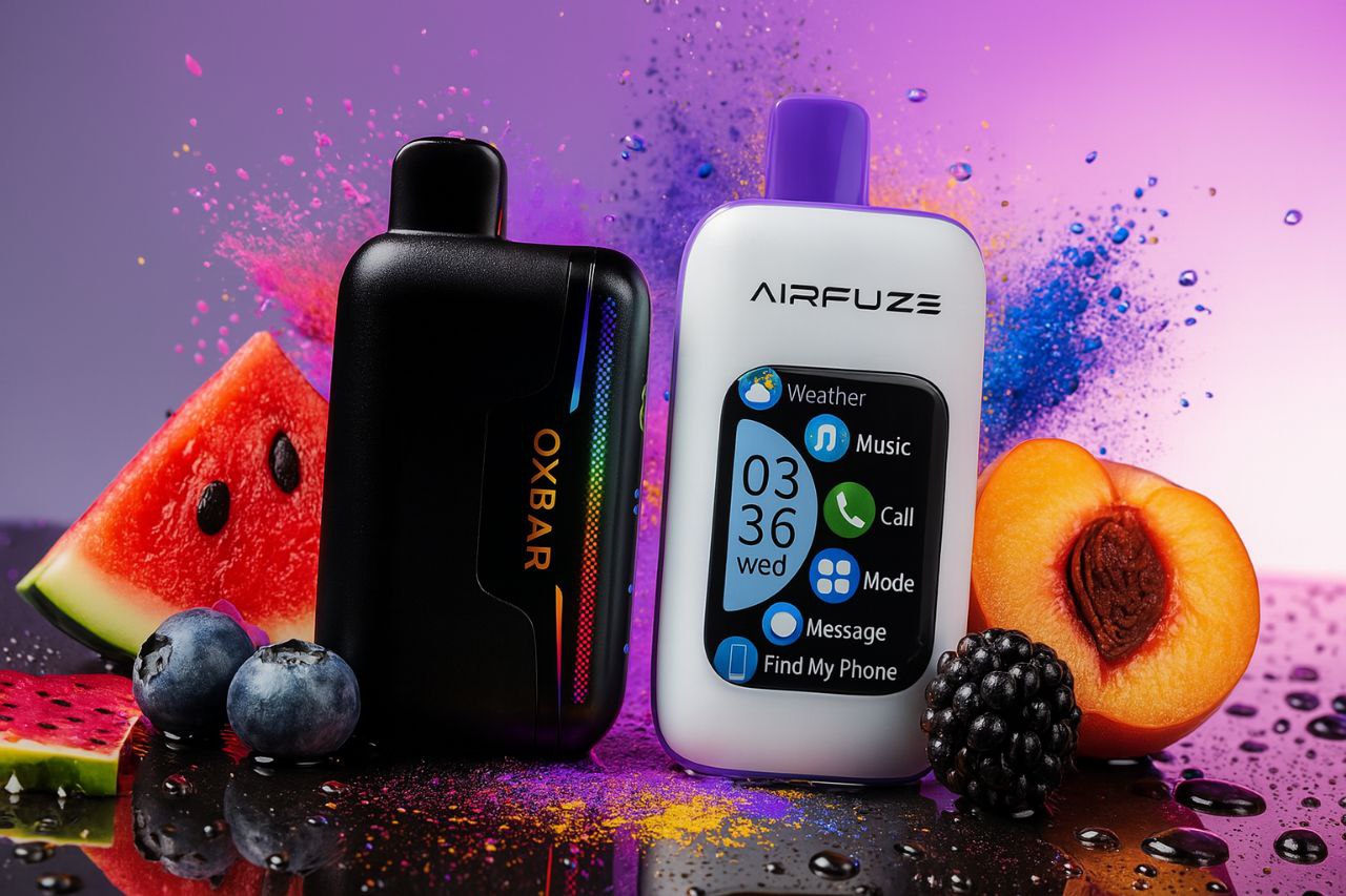 The image features two sleek vape devices placed on a wet surface surrounded by fresh fruits, including watermelon slices, blueberries, a peach, and a blackberry. The left device, labeled 